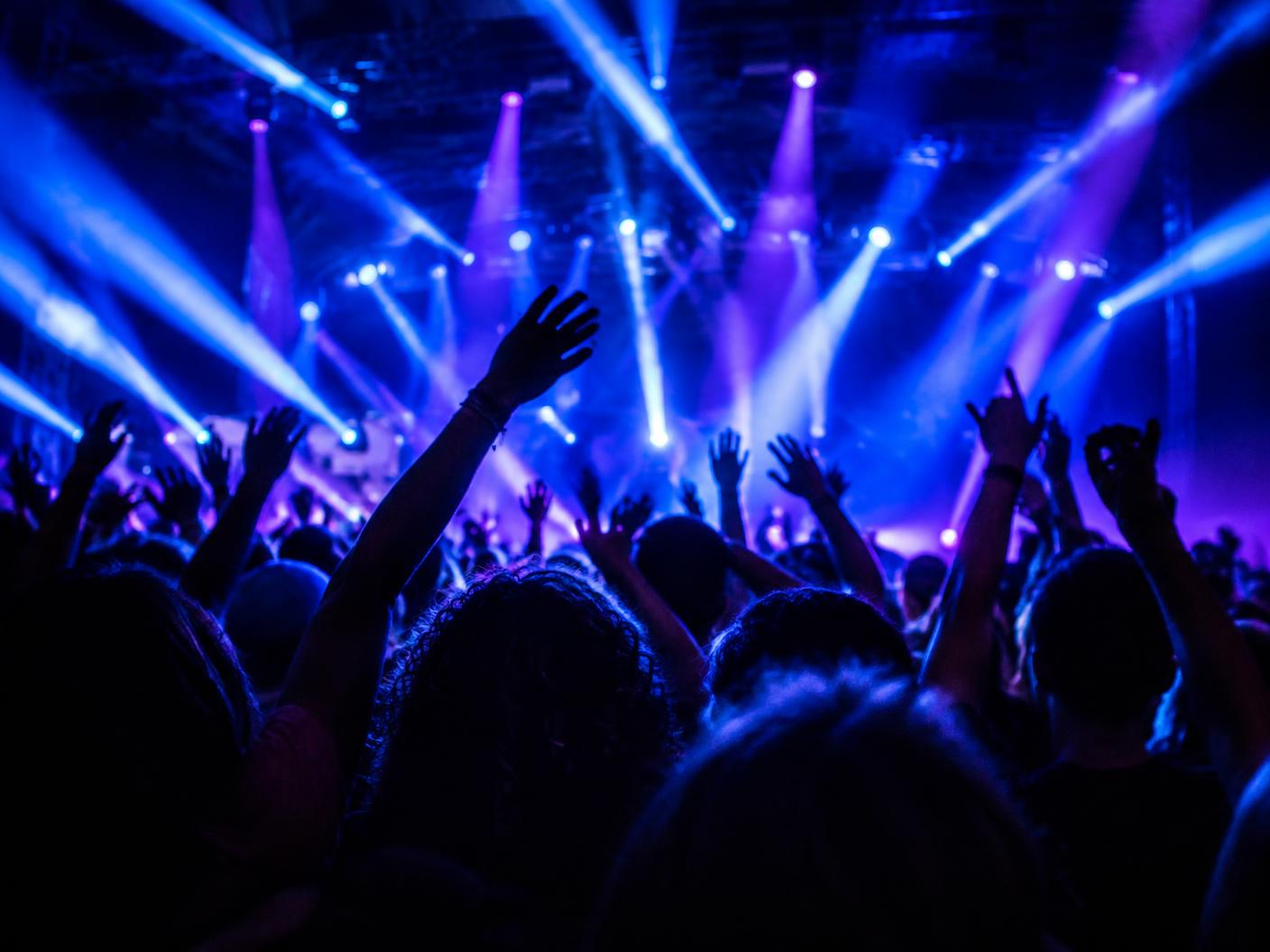 Público com as mãos levantadas durante um show